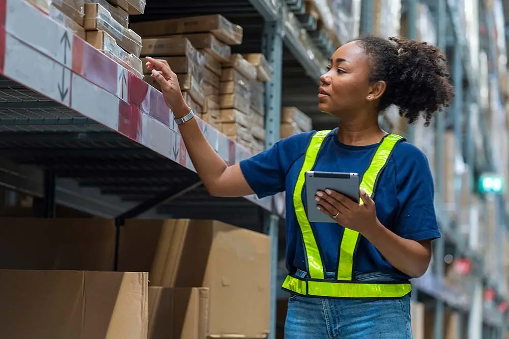 female worker checking inventory in warehouse