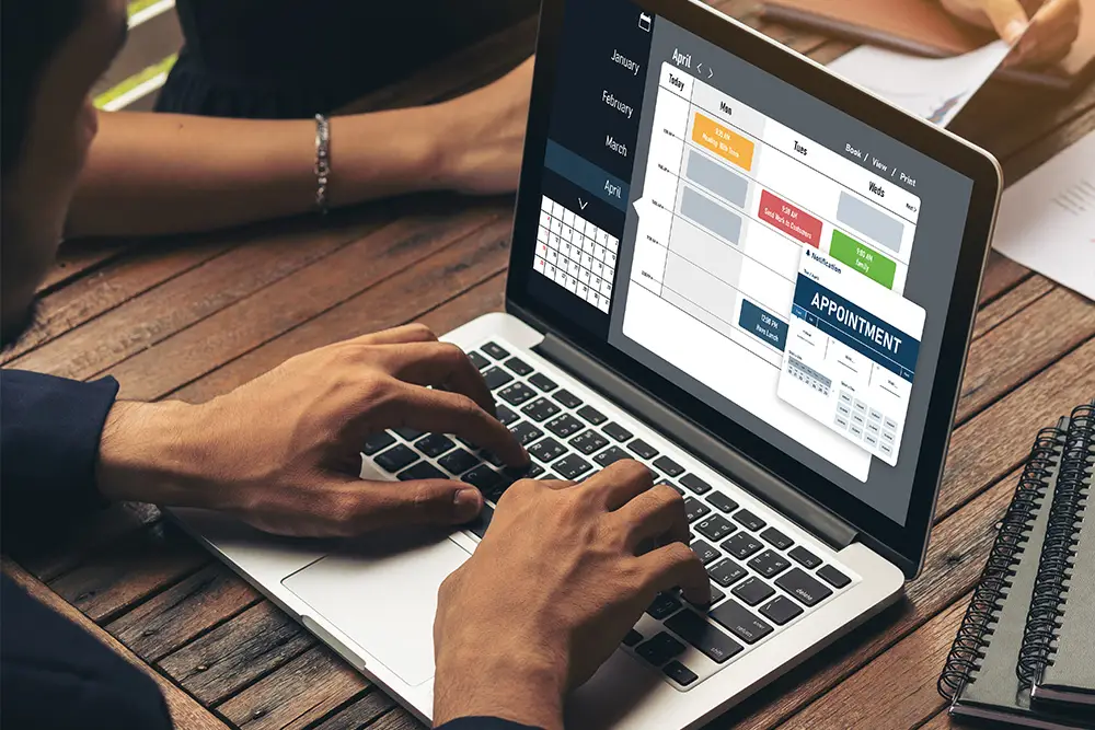 person on laptop viewing a calendar