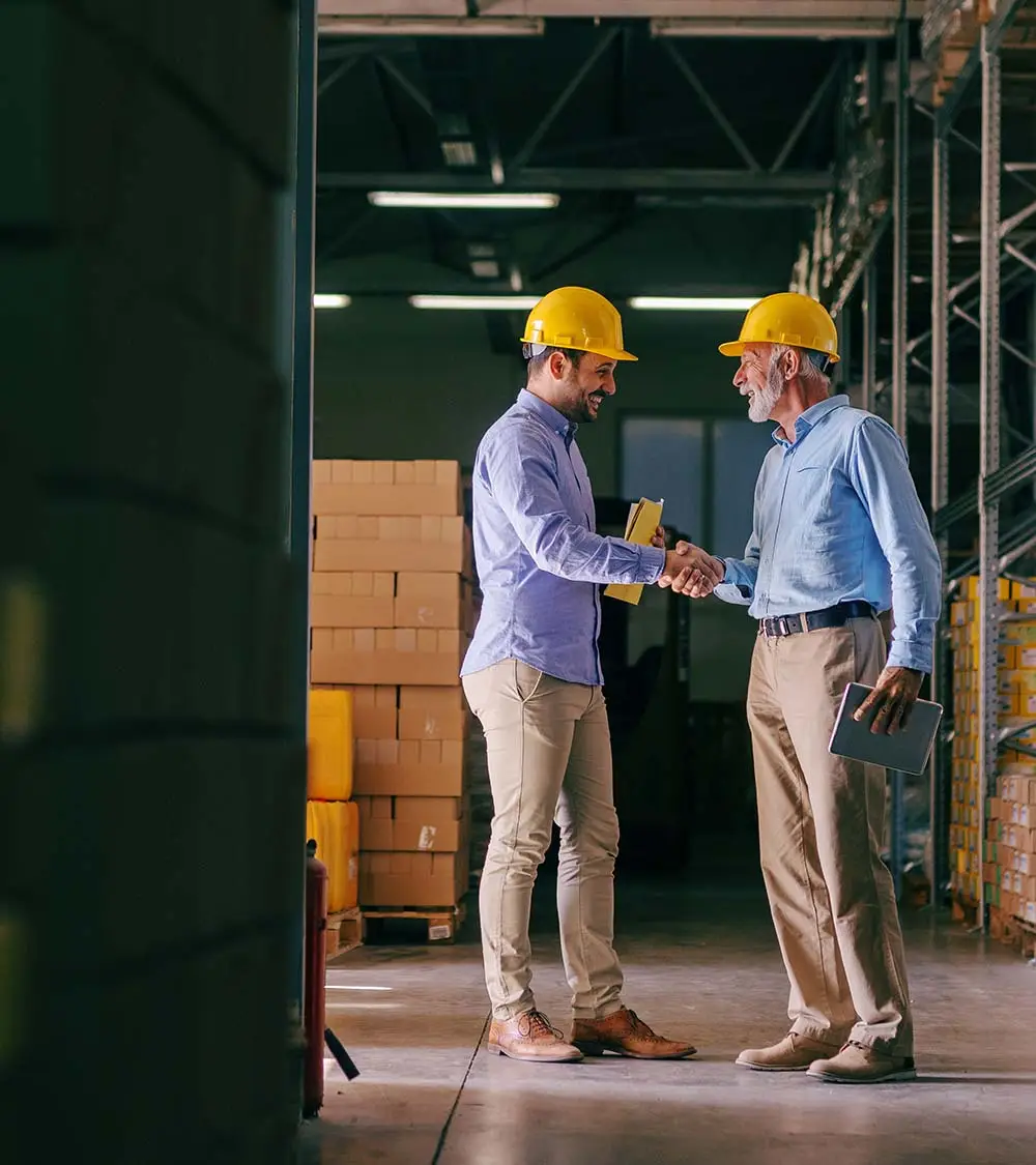 two men shaking hands in warehouse